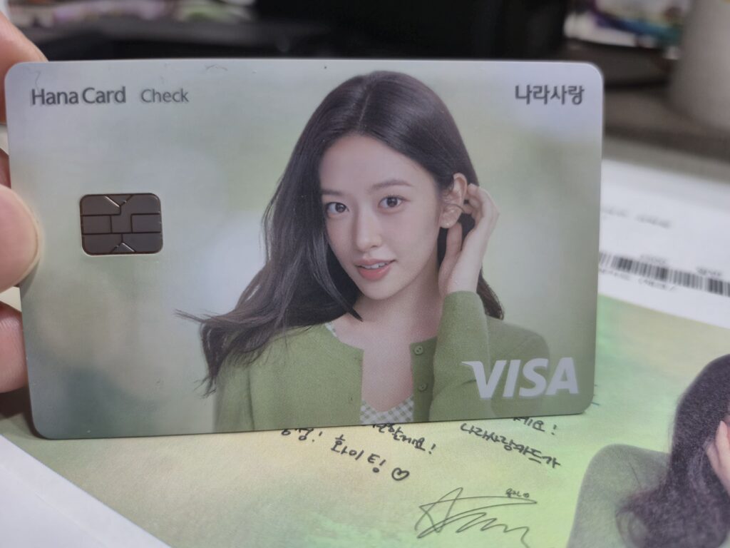 안유진의 얼굴이 크게 들어간 실제 나라사랑카드 플레이트 근접 사진, 비자(VISA) 로고와 함께 청순한 매력이 돋보이는 디자인.