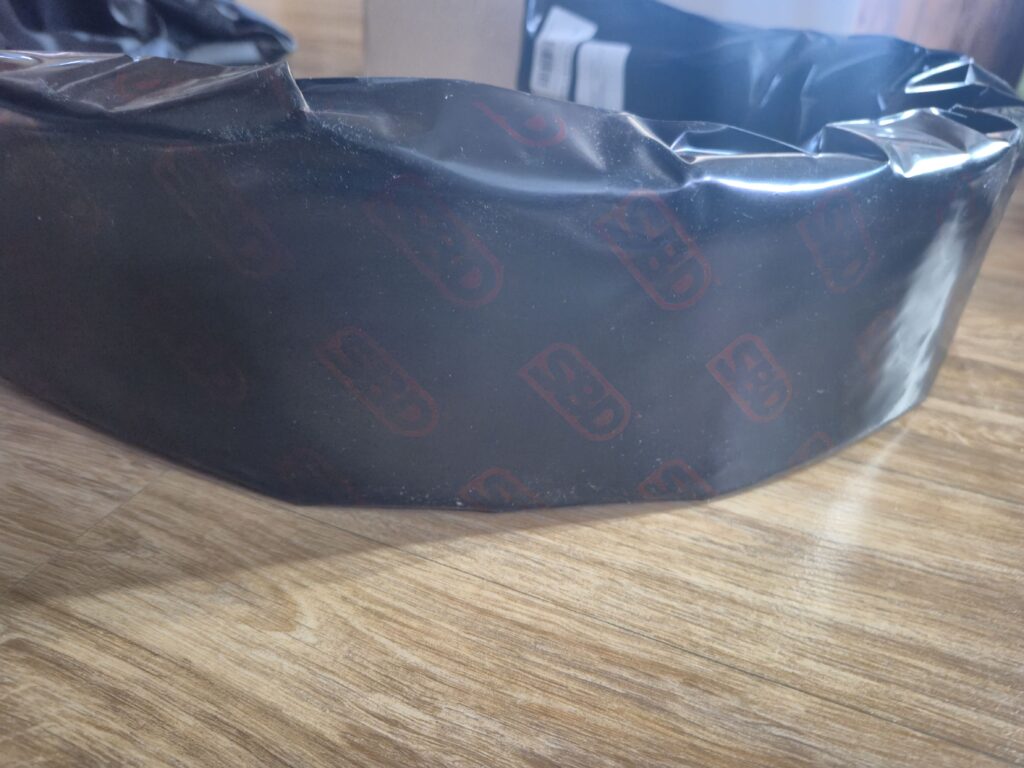 SBD 벨트가 'SBD' 로고가 새겨진 검정색 포장지에 감싸져있다.